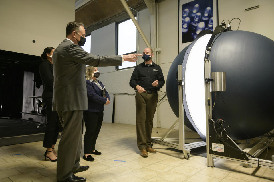 FILE - Doug Emhoff, husband of Vice President Kamala Harris, left, stands with Small Business Administration assistant administrator Natalie Madeira Cofield, left, and Rep. Susan Wild, D-Pa., center, as they listen to Mike Grather, center, president of Lightlab International, demonstrate equipment during a tour of the Bridgeworks Enterprise Center, a small business incubator, Wednesday, May 5 ,2021 in Allentown, Pa. (Ed Jones/ Pool via AP, File)