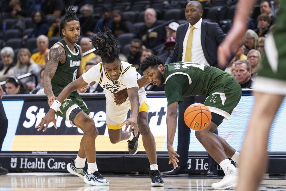 Missouri's Sean East II, center, battles Loyola Md's David Brown III, right, and D'Angelo Stines, left, for a rebound during the second half of an NCAA college basketball game Saturday, Nov. 25, 2023, in Columbia, Mo. Missouri won 78-70. (AP Photo/L.G. Patterson)