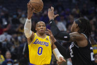 Los Angeles Lakers guard Russell Westbrook (0) passes the ball over Sacramento Kings center Richaun Holmes during the first quarter of an NBA basketball game in Sacramento, Calif., Tuesday, Nov. 30, 2021. (AP Photo/Randall Benton)