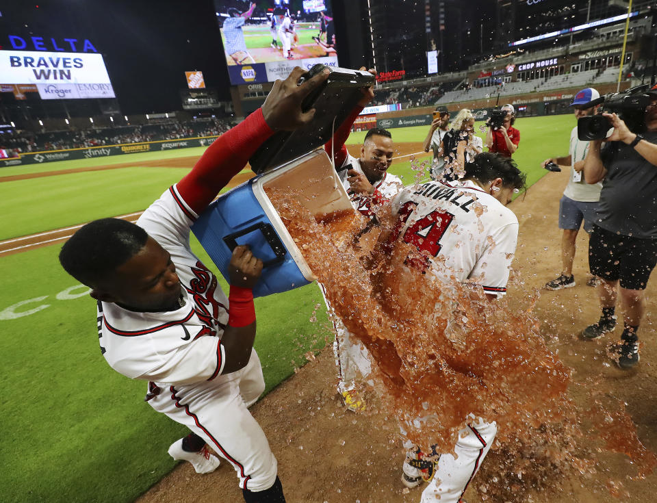 Atlanta Braves Guillermo Heredia, from left, and Orlando Arcia dunk outfielder Adam Duvall after he hit a walk-off RBI single to beat the San Francisco Giants after the ninth inning of a baseball game, Wednesday, June 22, 2022, in Atlanta. (Curtis Compton/Atlanta Journal-Constitution via AP)