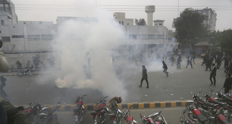 Police use tear gas shell to disperse angry lawyers back during a clash in Lahore, Pakistan, Wednesday, Dec. 11, 2019. Hundreds of Pakistani lawyers, angered over alleged misbehavior of some doctors toward one of their colleagues last month, stormed a cardiology hospital in the eastern city of Lahore, setting off scuffles with the facility's staff and guards that left heart patients unattended for several hours. (AP Photo/K.M. Chaudary)