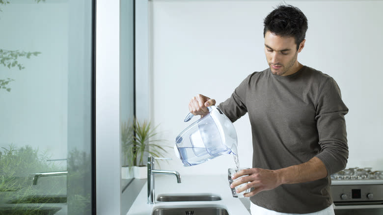 Man pouring filtered liquid