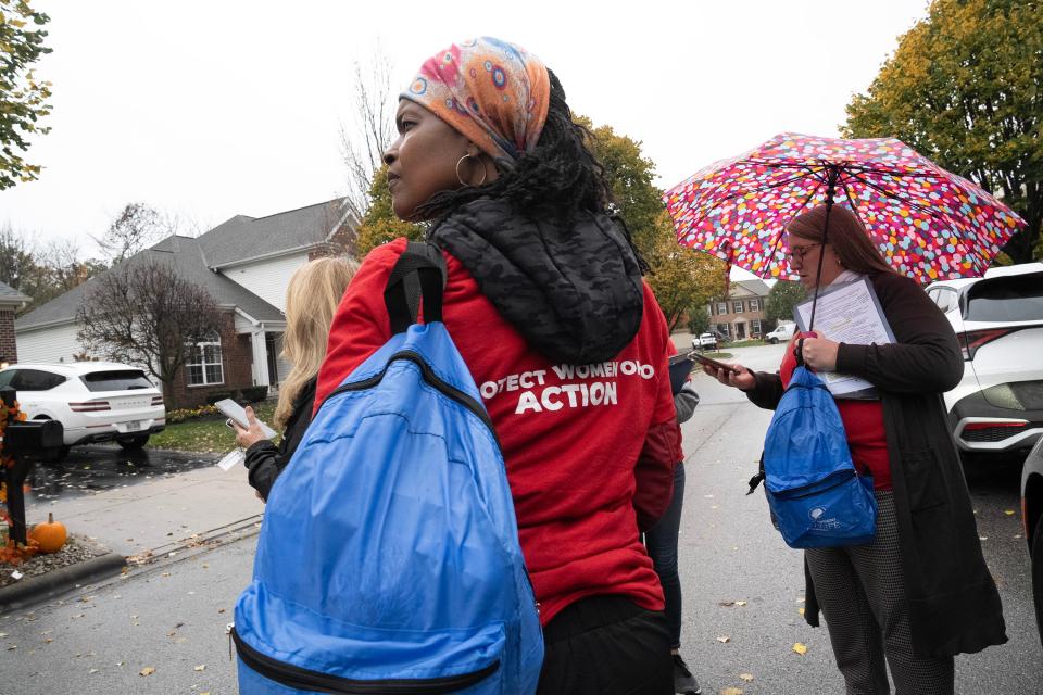 Sharon Bronson, of Madisonville, walks with other volunteers while canvassing in a Dublin neighborhood to distribute materials in opposition of Issue 1.