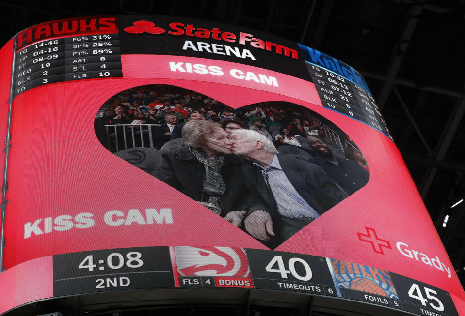 Former President Jimmy Carter kisses his wife, Rosalynn, after the two were spotted by the 'kiss cam" during the first half of an NBA basketball game between Atlanta Hawks and the New York Knicks Thursday, Feb. 14, 2019, in Atlanta. (AP Photo/John Bazemore)