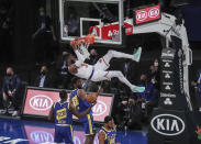 New York Knicks center Nerlens Noel hangs from the rim after a dunk against the Golden State Warriors during the first quarter of an NBA basketball game Tuesday, Feb. 23, 2021, in New York. (Wendell Cruz/Pool Photo via AP)