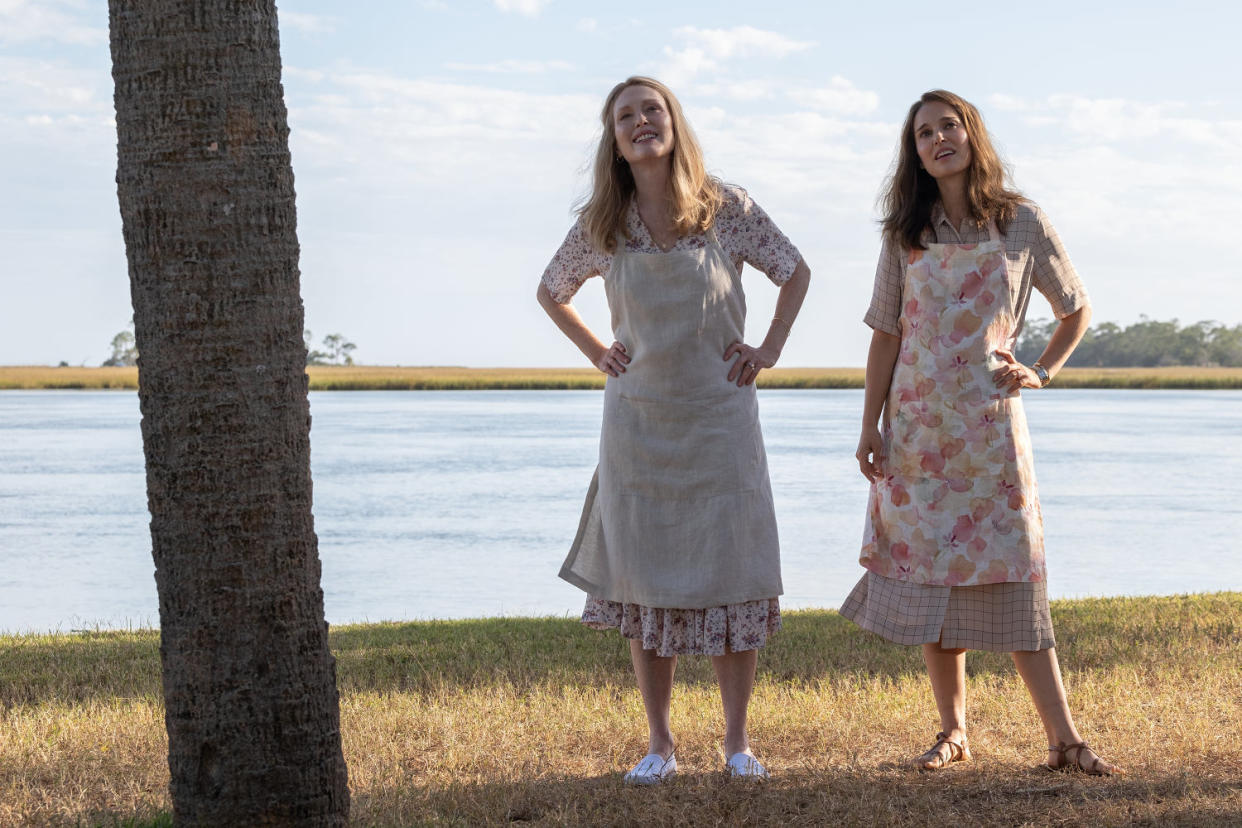Gracie and Elizabeth stand in front of water with hands on hips, wearing matching dresses  (Francois Duhamel / courtesy of Netflix)