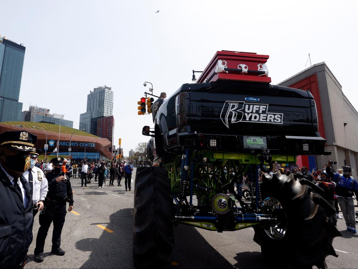 Members of the NYPD stand next to the monster truck holding the casket of US rapper DMX on Flatbush avenue outside the Barclays Center. (EPA)