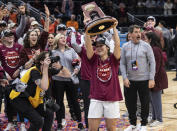 Virginia Tech guard Georgia Amoore holds a regional championship trophy above her head while celebrating after an Elite 8 college basketball game against Ohio State in the NCAA Tournament, Monday, March 27, 2023, in Seattle. (AP Photo/Caean Couto)