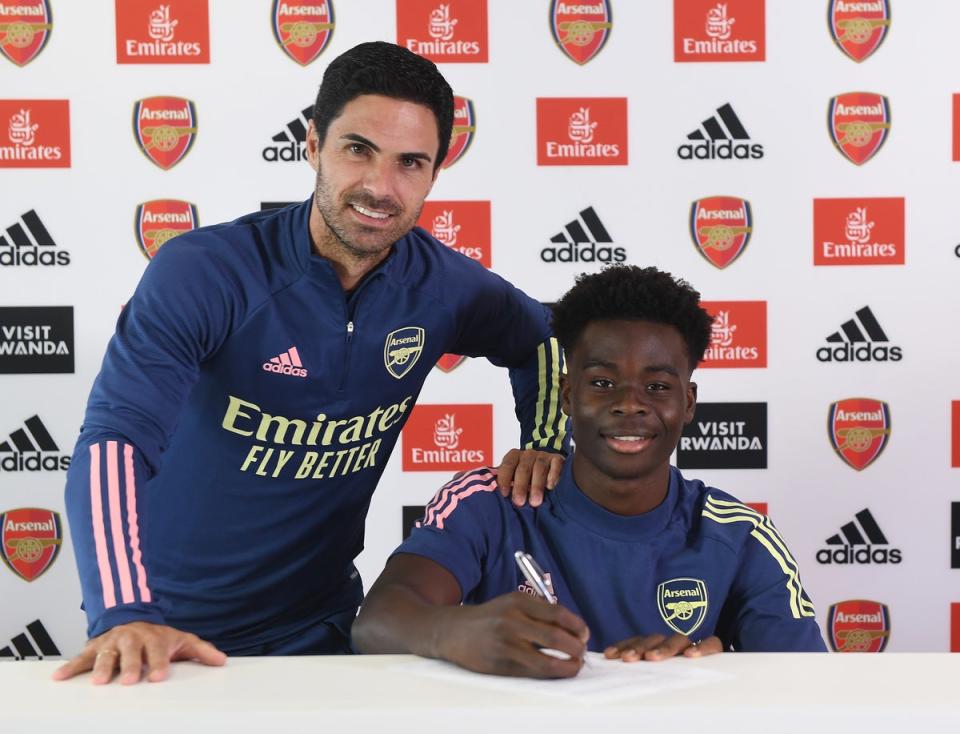 Saka with head coach Mikel Arteta after signing a new long-term contract with Arsenal in the summer of 2020 (Arsenal FC via Getty Images)