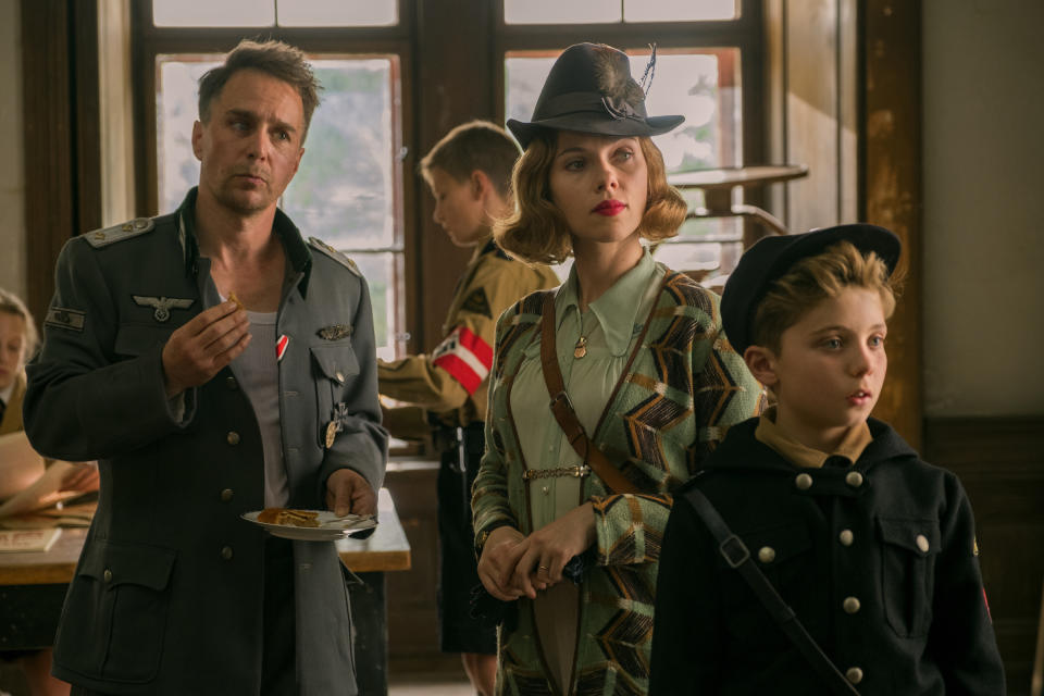 This image released by Fox Searchlight Pictures shows, from left, Sam Rockwell, Scarlett Johansson and Roman Griffin Davis in a scene from the WWII satirical film "Jojo Rabbit." (Larry Horricks/Fox Searchlight Pictures via AP)