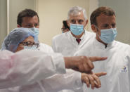 French President Emmanuel Macron listens to researchers as he visits an industrial development laboratory at French drugmaker's vaccine unit Sanofi Pasteur plant in Marcy-l'Etoile, near Lyon, central France, Tuesday, June 16, 2020.The visit comes after rival pharmaceutical company AstraZeneca this weekend announced a deal to supply 400 million vaccine doses to EU countries, including France. (AP Photo/Laurent Cipriani, Pool)
