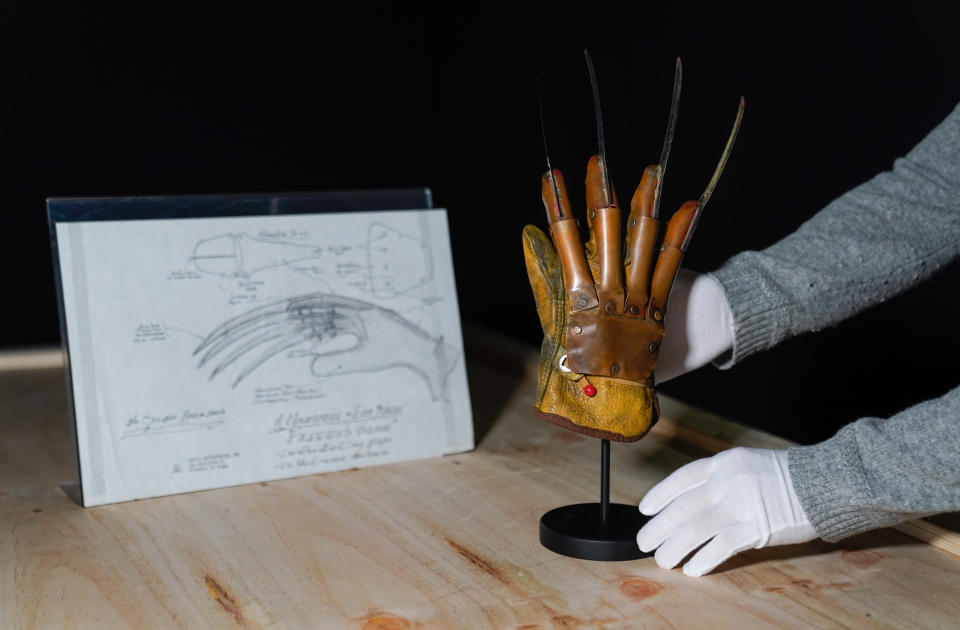 A Propstore employee places Freddy Krueger's (Robert Englund) screen matched metal glove armature (right) next to a hand drawn schematic (estimate £200,000 - 400,000) from the films 'A Nightmare on Elm street' and 'A Nightmare on Elm Street 2: Freddy's Revenge' respectively, during a preview for the showbiz memorabilia auction, at the Propstore in Rickmansworth, Hertfordshire. Picture date: Wednesday September 20, 2023. (Photo by Andrew Matthews/PA Images via Getty Images)