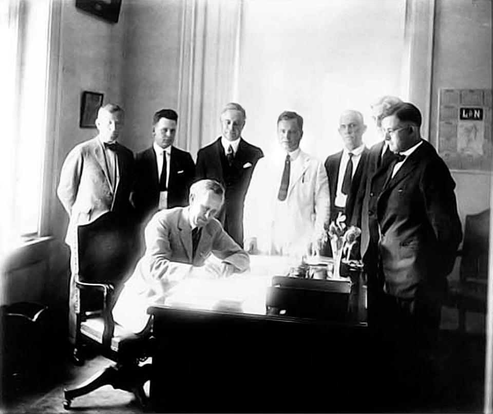 Florida Gov. Carey A. Hardee (seated) signs the bill that established Collier County on May 8, 1923. In return, Barron Gift Collier, standing third from left, revived the Tamiami Trail project.