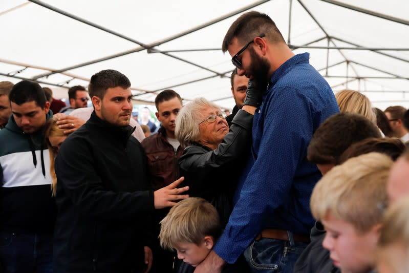 Howard Miller reacts with relatives during the burial of his wife Rhonita Miller and their children Howard, Kristal, Titus, and Teana, who were killed by unknown assailants, in LeBaron