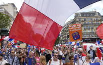 Protestors hold signs which read in French, "freedom" and 'no to the vaccine passport" as they attend a demonstration in Paris, France, Saturday, July 31, 2021. Demonstrators gathered in several cities in France on Saturday to protest against the COVID-19 pass, which grants vaccinated individuals greater ease of access to venues. (AP Photo/Michel Euler)