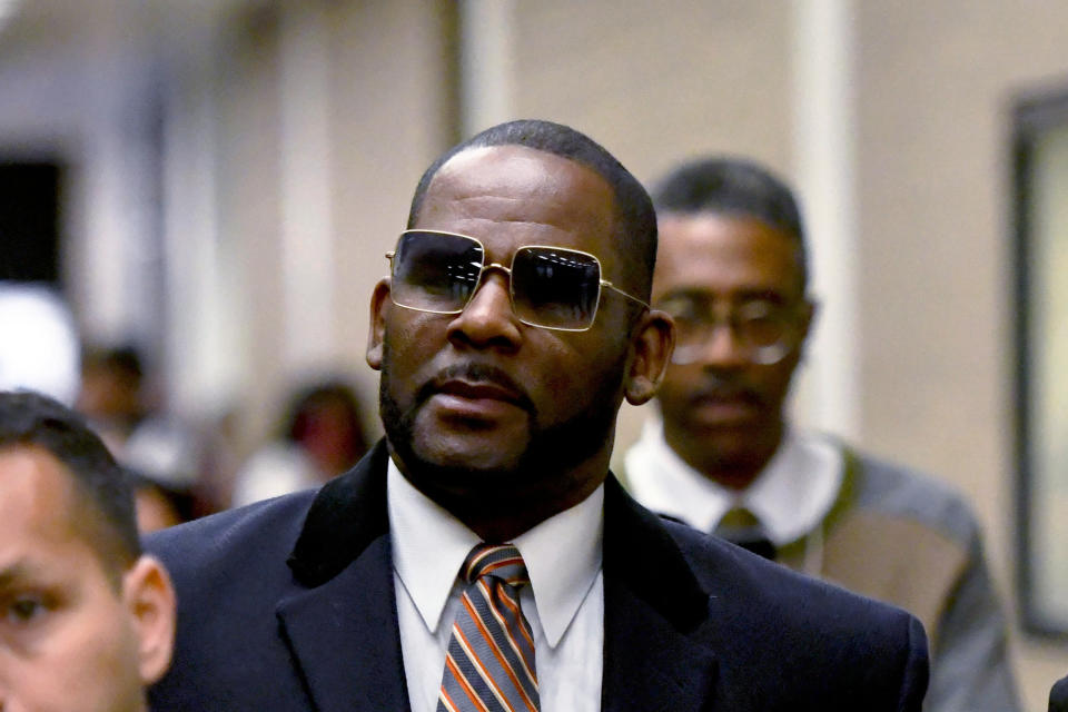 FILE - R. Kelly, center, leaves the Daley Center after a hearing in his child support case May 8, 2019, in Chicago. Federal prosecutors asked a judge Thursday, Feb. 16, 2023, to give singer R. Kelly 25 more years in prison for his child pornography and enticement convictions last year in Chicago, which would add to 30 years he recently began serving in a New York case. (AP Photo/Matt Marton, File)