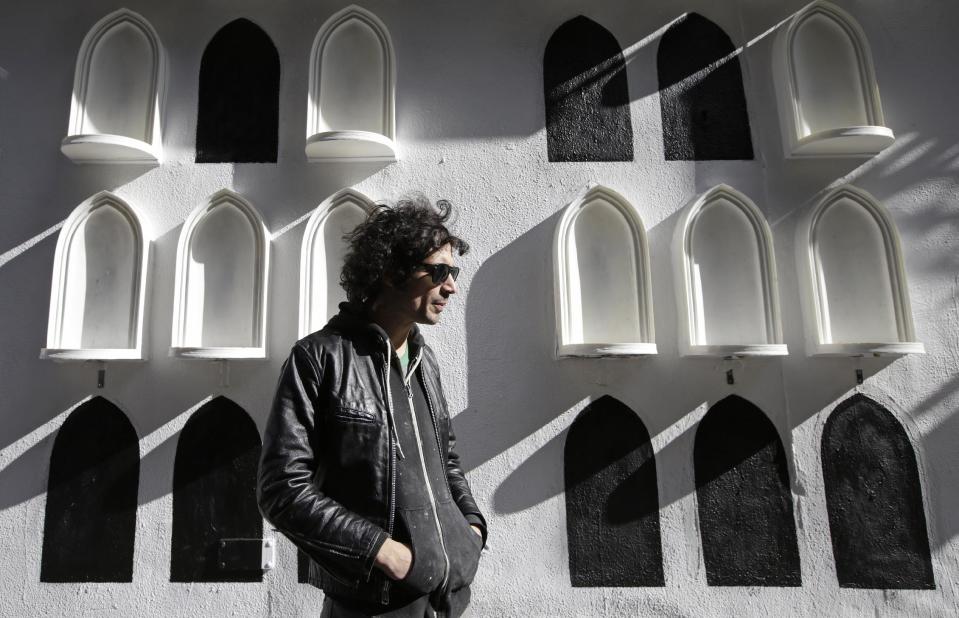 This Oct. 24, 2013 photo shows The Strokes' drummer Fabrizio Moretti in front of his installation on the exterior wall of the SoHo Rag & Bone store in New York. The installation is part of the clothing brand's ongoing urban art project, in which they get artists to revamp the store's façade. (AP Photo/Kathy Willens)