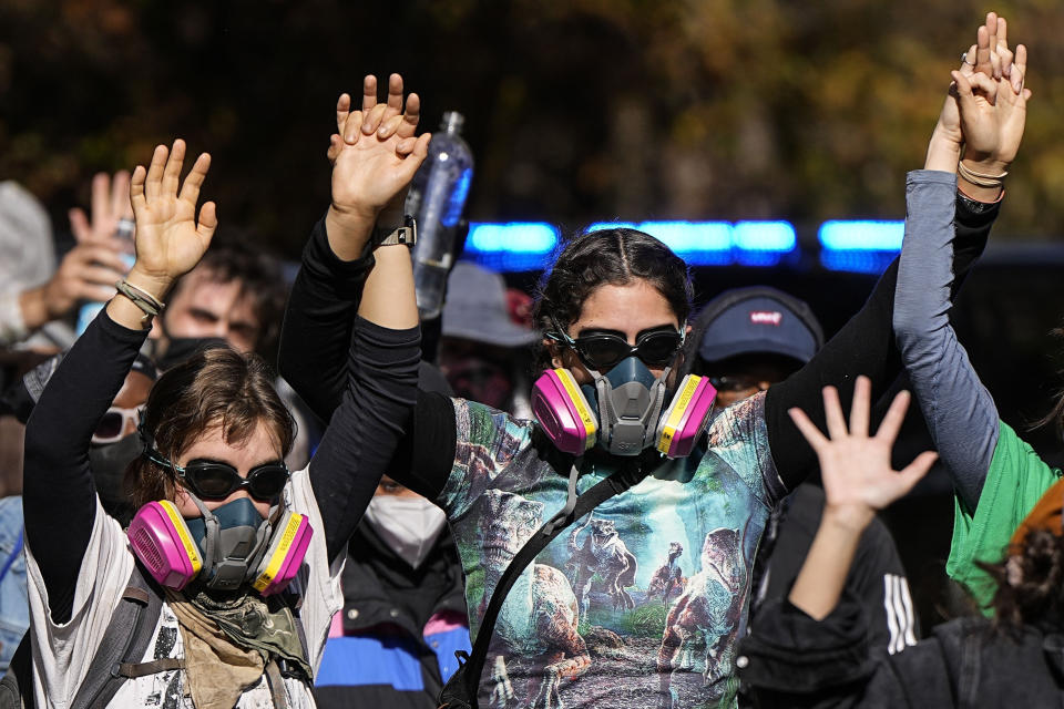 Protesters leave a wooded area after gas was used during a demonstration in opposition to a new police training center, Monday, Nov. 13, 2023, in Atlanta. (AP Photo/Mike Stewart)