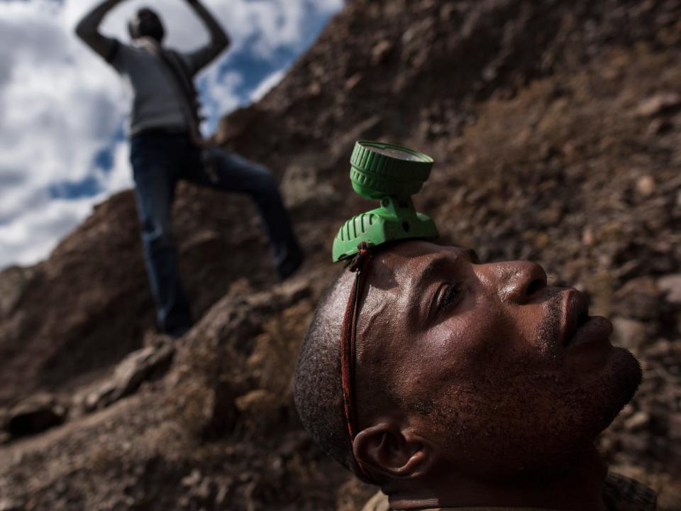 A digger wearing a headlamp readies to go into a mine shaft in Kawama, Democratic Republic of Congo