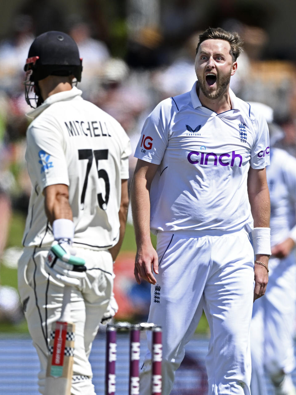 England's Ollie Robinson, right, celebrates taking the wicket of New Zealand's Daryl Mitchell on the second day of their cricket test match in Tauranga, New Zealand, Friday, Feb. 17, 2023. (Andrew Cornaga/Photosport via AP)