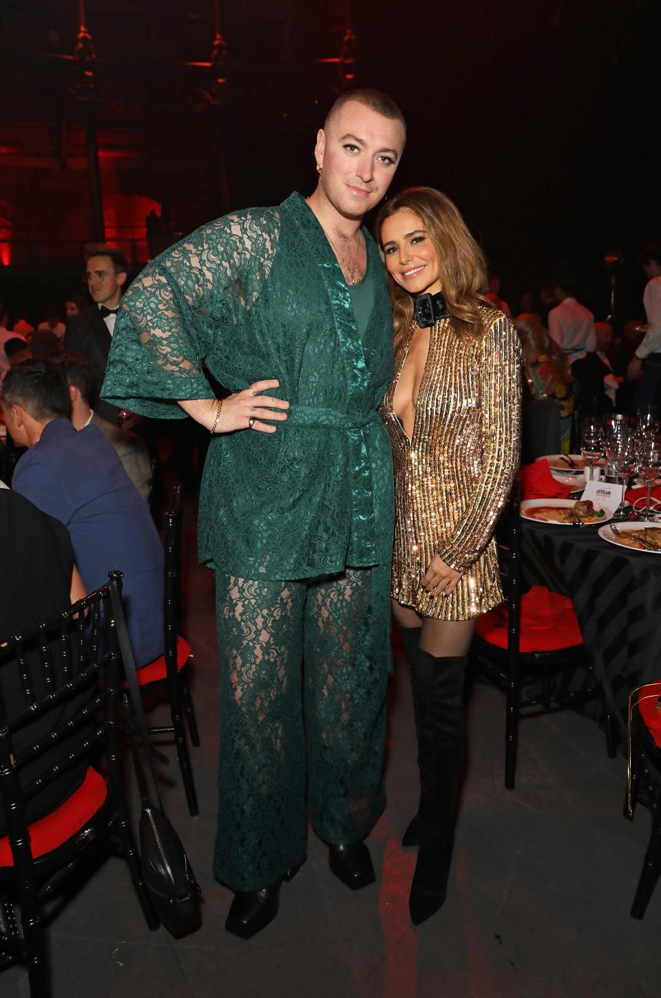 Sam Smith and Cheryl Cole hug and pose in front of a dark room at the Virgin Atlantic Attitude Awards in October 2019.