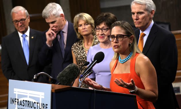 Sen. Kyrsten Sinema (D-Ariz.) speaks as (from left) Sens. Kevin Cramer (R-N.D.), Bill Cassidy (R-La.), Lisa Murkowski (R-Alaska), Susan Collins (R-Maine) and Rob Portman (R-Ohio) listen during a news conference after a procedural vote for the bipartisan infrastructure framework. (Photo: Alex Wong/Getty Images)