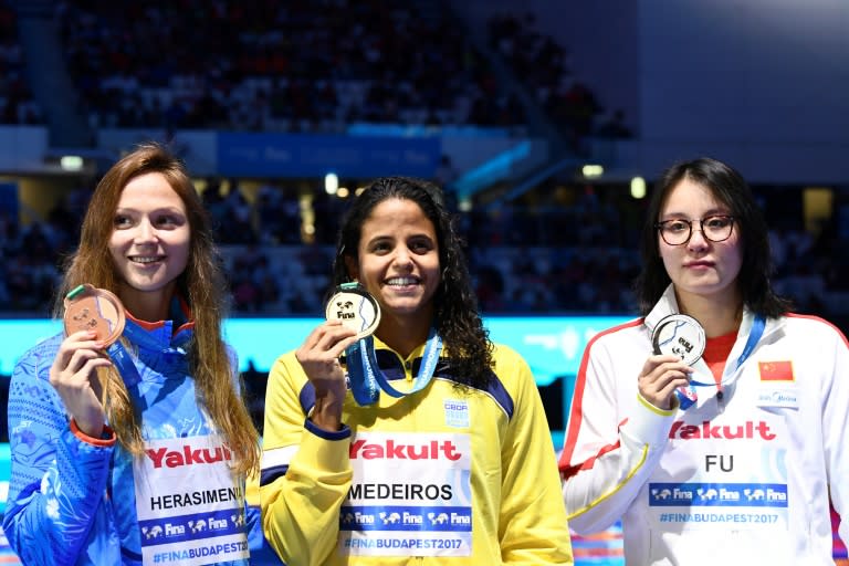 Brazil's Etiene Medeiros (C) won the women's 50m backstroke, edging out China's Fu Yuanhui (R), who had become an internet celebrity due to a viral video of her tears of joy at the 2016 Rio Olympics but now struggled to hold back her disappointment