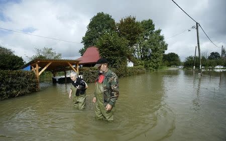 A couple wades through a flooded street in Zazina village, central Croatia, September 15, 2014. REUTERS/Antonio Bronic