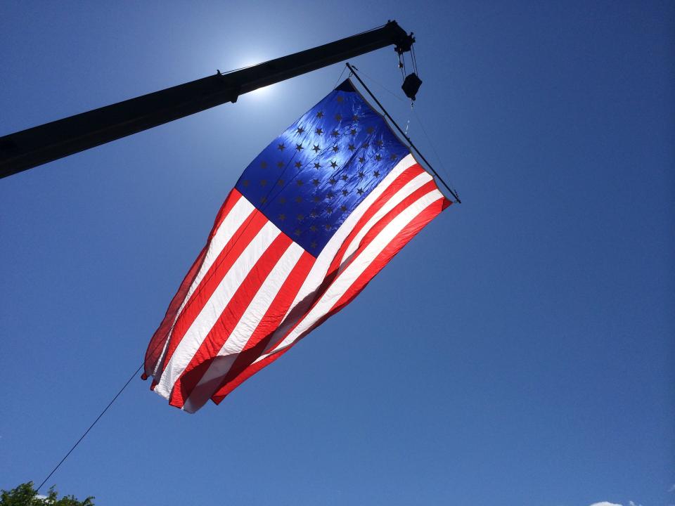 An oversized American flag hangs over the Essex Memorial Day Parade route in 2015.