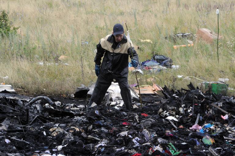 A rescue worker uses sticks to mark the location where bodies have been found at the crash site of the Malaysian airliner, in Grabove, east Ukraine, on July 18, 2014