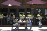 FILE - In this July 18, 2020, file photo patrons eat at table set up on a sidewalk in Burbank, Calif. The pandemic began with devastation in the New York City area, and was followed by a summertime crisis in the Sun Belt. But it is now striking cities with much smaller populations, often in conservative corners of America where anti-mask sentiment runs high, creating problems at hospitals and schools in the Midwest and West. (AP Photo/Marcio Jose Sanchez, File)