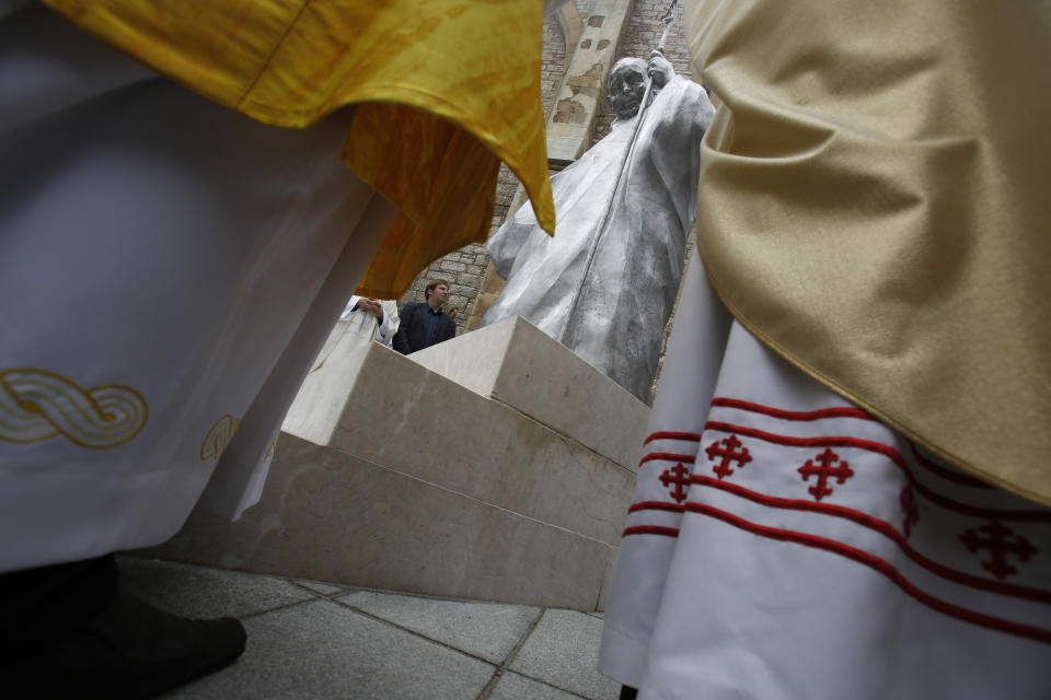 The statue of Pope John Paul II is unveiled during a ceremony in front of the cathedral in Sarajevo, Bosnia, on Wednesday, April 30, 2014. Thousands of Bosnians have celebrated the canonization of Pope John Paul II by unveiling a statue in the heart of Sarajevo. John Paul’s support for Sarajevo's resistance to nationalist efforts to destroy the traditional inter-cultural and inter-religious fabric of the city during the 1992-95 war made him very popular among the city's predominantly Muslim population. The crowd shouted “long live the pope” as the three meter-high statue was unveiled Wednesday in front of the cathedral. (AP Photo/Amel Emric)