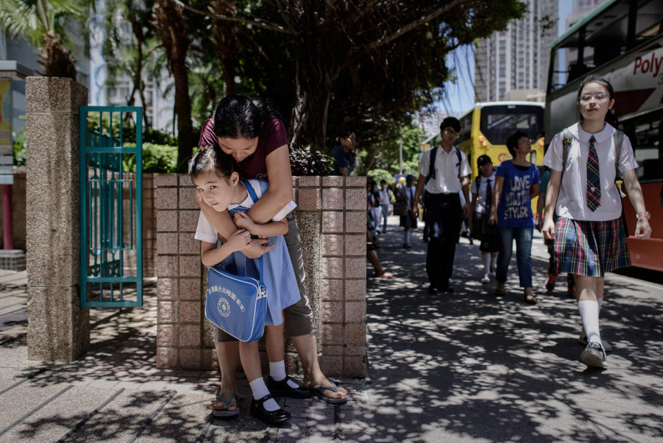 Maia, 5, gets a hug from her nanny on her way to school outside her home in Hong Kong on June 18, 2013.  