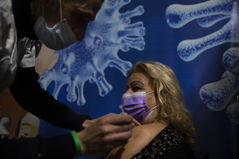 A woman receives a coronavirus vaccine from medical staff at a COVID-19 vaccination center in Ramat Gan, Israel, Sunday, Jan. 3, 2021. (AP Photo/Oded Balilty)