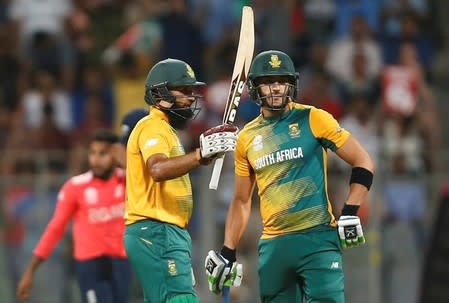 Cricket - South Africa v England - World Twenty20 cricket tournament - Mumbai, India, 18/03/2016. South Africa's Hashim Amla raises his bat to celebrate scoring his half century as his captain Faf du Plessis looks on. REUTERS/Danish Siddiqui