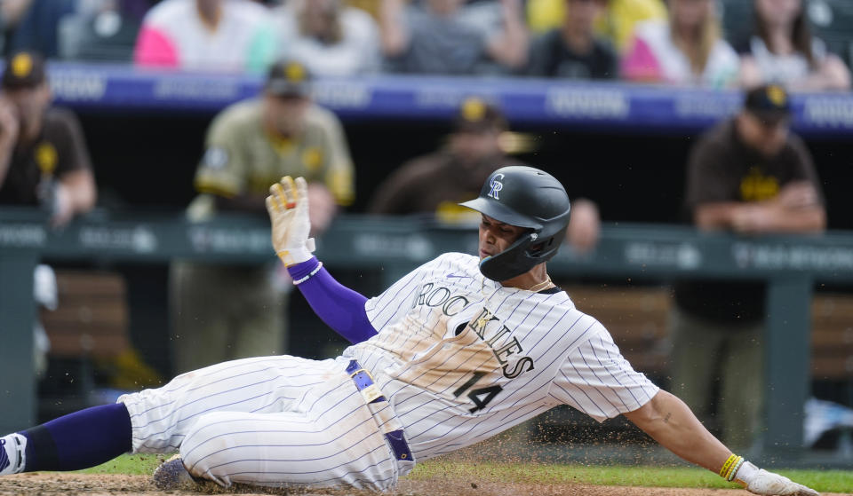 Colorado Rockies' Ezequiel Tovar scores the tying run on a wild pitch thrown by San Diego Padres' Wandy Peralta during the eighth inning of a baseball game Thursday, April 25, 2024, in Denver. (AP Photo/David Zalubowski)