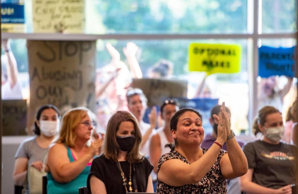 People clap during the Shawnee Mission School District meeting Monday as parents express opposition to their children wearing mask in the 2021-22 school year. Both sides voiced their opinions before the board.