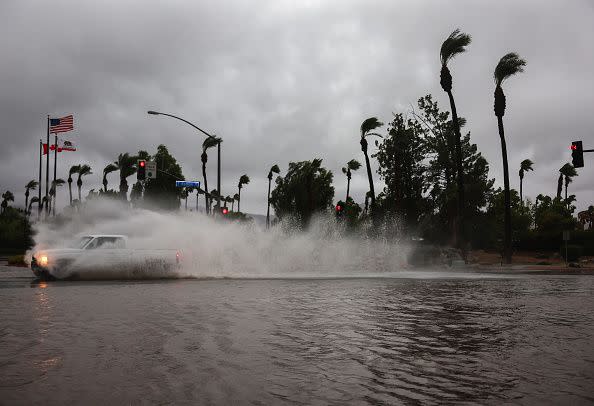 CATHEDRAL CITY, CALIFORNIA - AUGUST 20: A vehicle drives through a flooded street as Tropical Storm Hilary moves through the area on August 20, 2023 in Cathedral City, California. Southern California is under a first-ever tropical storm warning as Hilary impacts parts of California, Arizona and Nevada. All California state beaches have been closed in San Diego and Orange counties in preparation for the impacts from the storm which was downgraded from hurricane status. (Photo by Mario Tama/Getty Images)