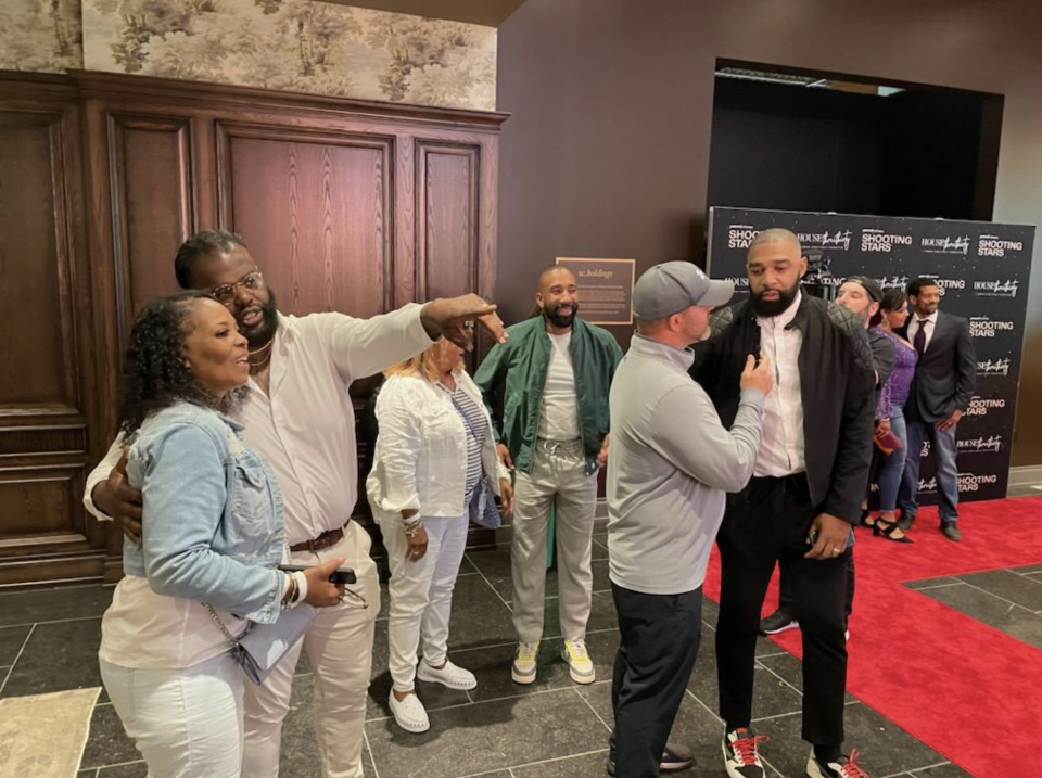 Sian Cotton (near camera), Dru Joyce III (green jacket), Willie and Romeo Travis (being interviewed), who all played for St. Vincent-St. Mary High School on the red carpet for the premiere of "Shooting Stars" in Akron.