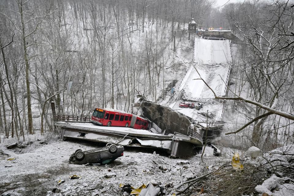 A Port Authority bus that was on a bridge when it collapsed, Jan. 28, 2022, is visible in Pittsburgh's East End. The two-lane bridge collapsed in Pittsburgh early Friday, prompting rescuers to rappel nearly 150 feet (46 meters) while others formed a human chain to help rescue multiple people from a dangling bus.