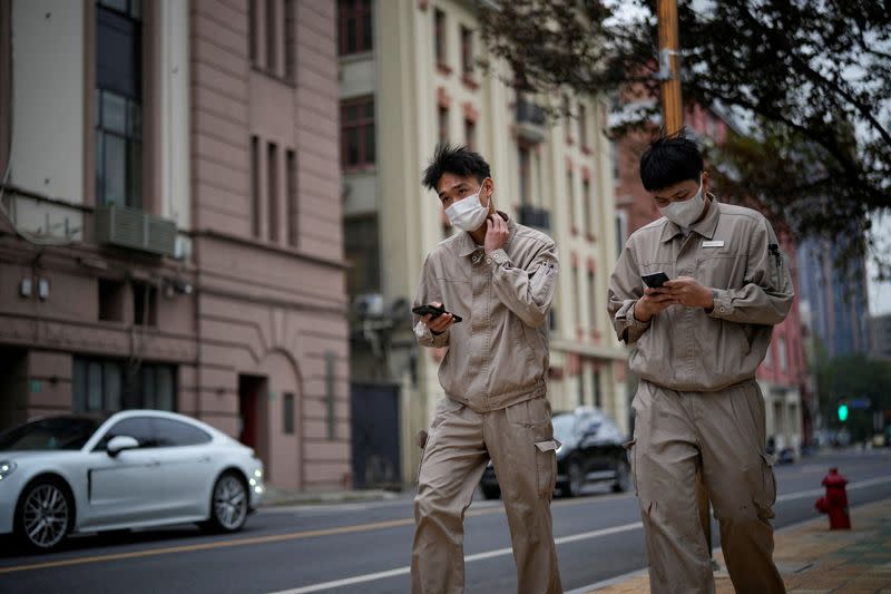 Two men wearing face masks walk on a street, as COVID-19 outbreaks continue in Shanghai