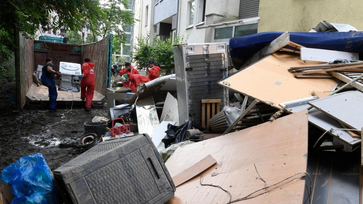 Helfer beseitigen in Opladen in Nordrhein-Westfalen die nach der Flutkatastrophe zurückgebliebenen Müllberge.