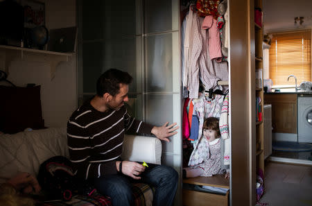 Adi, 37, who works for a removal company, plays hide and seek with his daughter Elena, who is two years and seven-months old, at their home in London, Britain, February 3, 2019. REUTERS/Alecsandra Dragoi