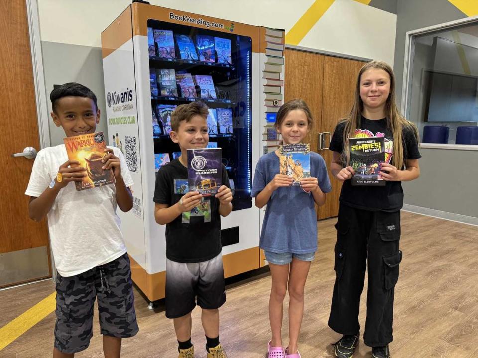 From left, Peyton Vaughn, 7; James Huston, 9; Amelia Vollchansky, 9; and Hazel Huston, 11, pose with books they selected from the book vending machine at the Rancho Cordova Youth Center.