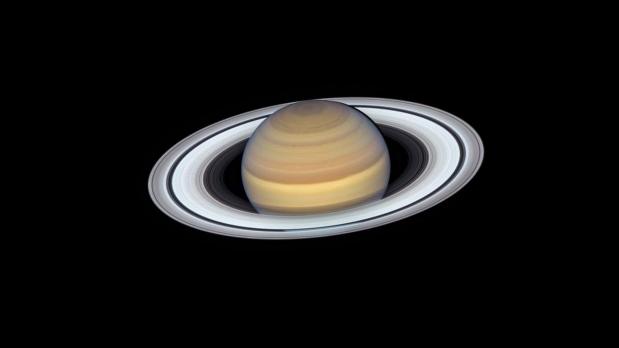  a brown planet surrounded by white and grey rings 