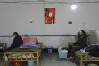 In this Friday, Feb. 21, 2020, photo, a man eats a meal at a temporary hospital at Tazihu Gymnasium in Wuhan in central China's Hubei province. China's leadership sounded a cautious note Friday about the country's progress in halting the spread of the new virus that has now killed more than 2,200 people, after several days of upbeat messages. (Chinatopix via AP)