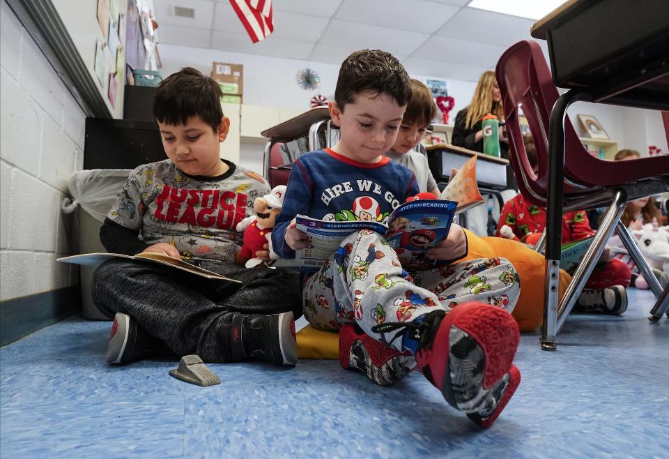 Second-graders Anderson Lemos, left, and Kieran O'Connor read on the floor at Evans Park Elementary School in Pearl River during the 40th Rockland Read-in.