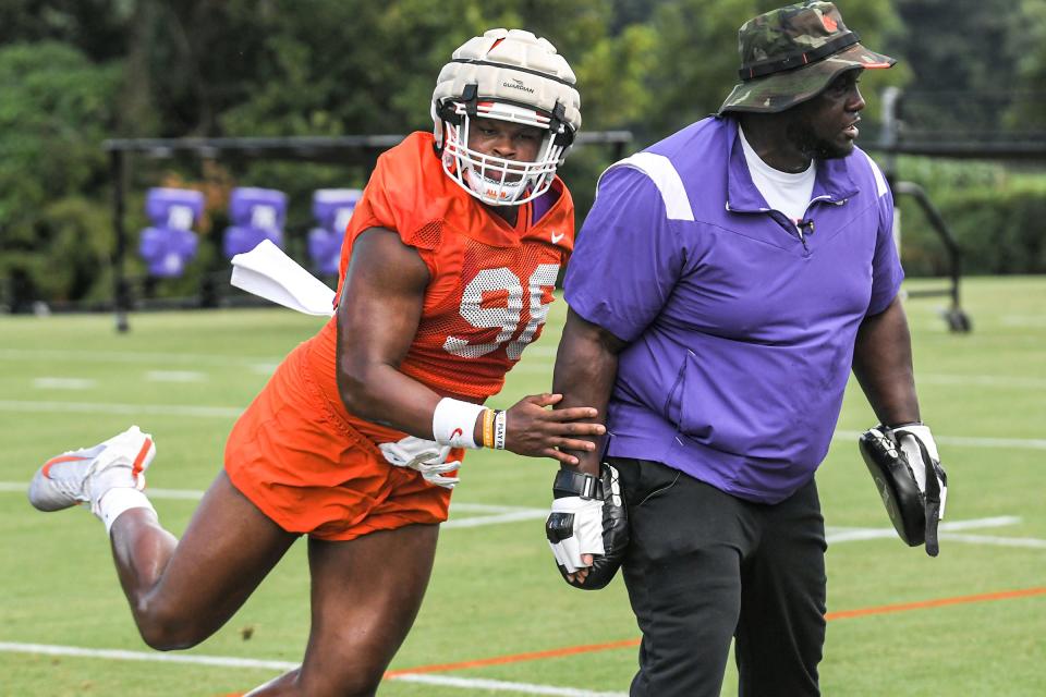 Clemson defensive end Myles Murphy (98) runs around defensive tackles Coordinator Nick Eason during practice at the Poe Indoor Facility in Clemson Monday, August 8, 2022. 