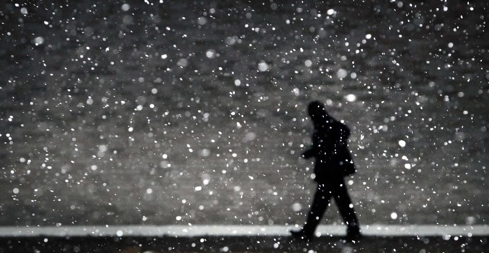 A traveler at the Memphis Airport hustles through the flakes of falling snow to make his flight on March 3, 2014, after a winter storm covered parts of Memphis in a blanket of ice overnight.