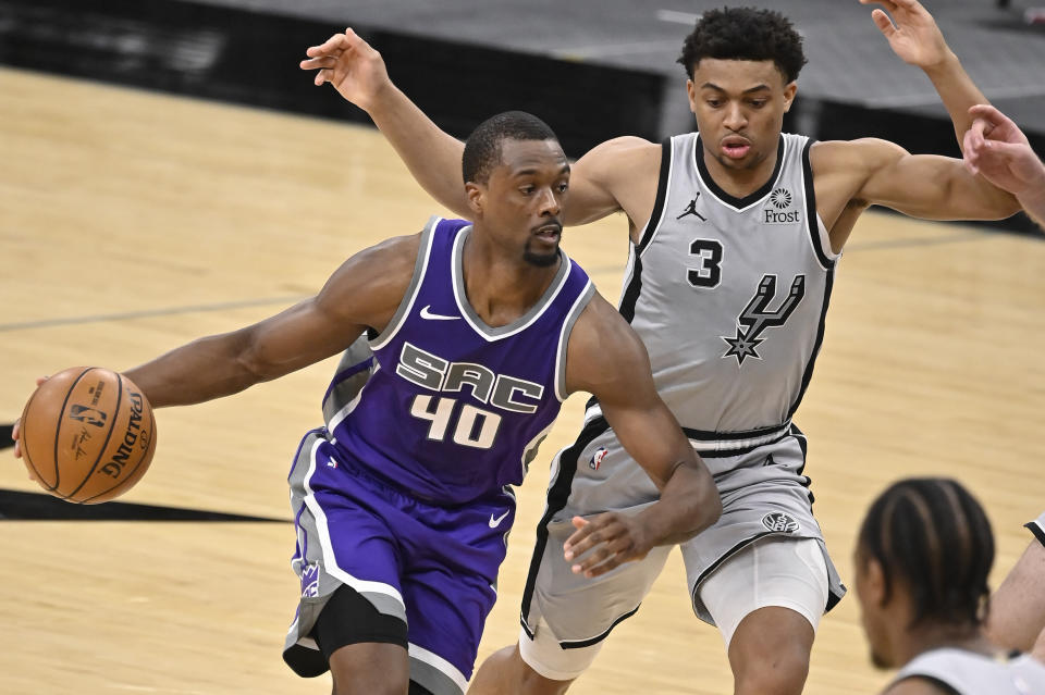 Sacramento Kings' Harrison Barnes (40) drives around San Antonio Spurs' Keldon Johnson during the second half of an NBA basketball game on Monday, March 29, 2021, in San Antonio. (AP Photo/Darren Abate)